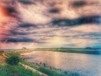 Scenic view of field against dramatic sky