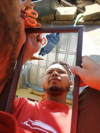Portrait of young man holding window
