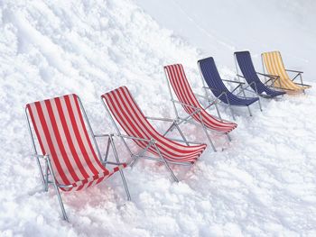 Row of relaxing chairs on snow