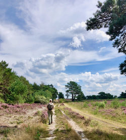 Man walking on field against sky