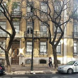 People on street against buildings in city