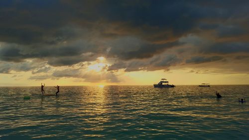 Scenic view of sea against stormy clouds during sunset