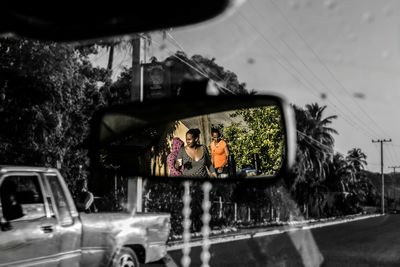 Reflection of woman on side-view mirror of car