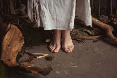 Close up barefoot woman standing in woodworking workshop concept photo