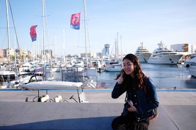 Young woman in harbor against sky