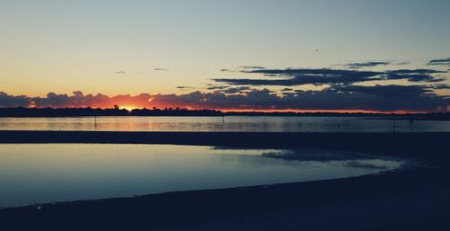 Scenic view of lake against romantic sky at sunset