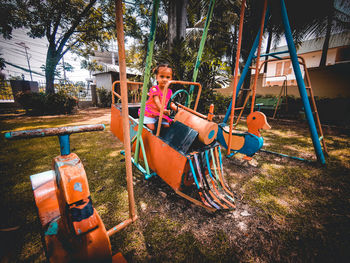 Girl sitting on swing at playground