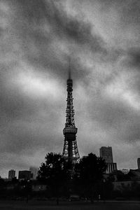 Low angle view of communications tower against cloudy sky