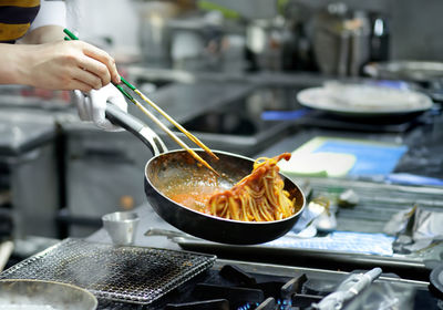 Cropped hand preparing food in kitchen