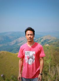 Portrait of mature man standing against mountains