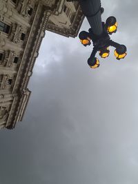 Low angle view of street light and building against sky