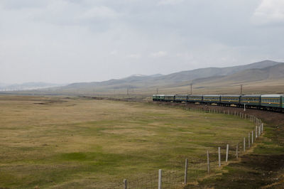 Train passing by landscape against sky