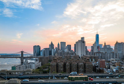 Skyline view of downtown new york and the brooklyn bridge at sunset.