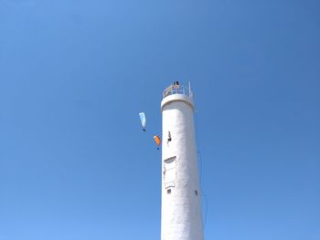 Low angle view of lighthouse against clear blue sky