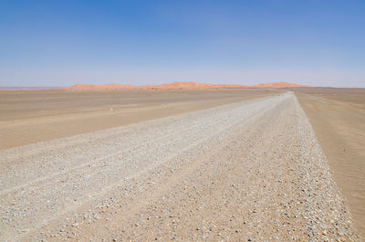 Sand dunes in desert against clear sky