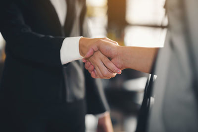 Midsection of couple holding hands