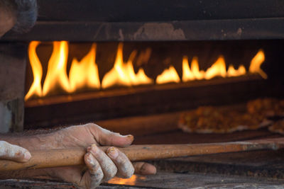 Cropped image of chef baking pizzas in oven