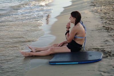 Full length of woman sitting on beach