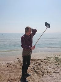 Full length of man photographing on beach