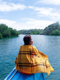 Rear view of man on lake against sky