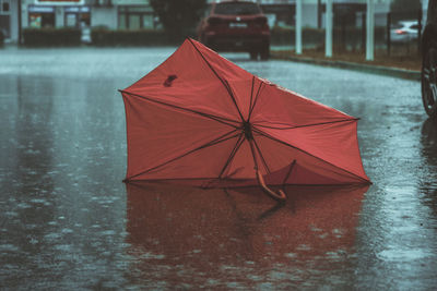 Close-up of wet red umbrella in rainy season