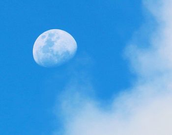 Low angle view of moon against blue sky