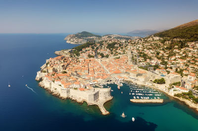 High angle view of buildings by sea against sky