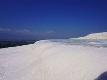 Scenic view of beach against blue sky