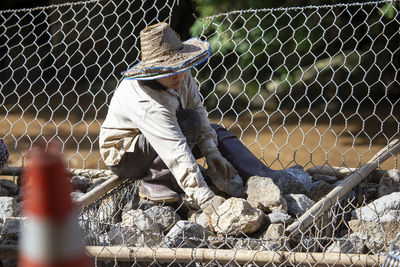 Man seen through chainlink fence