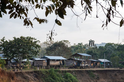 Houses by trees and house against sky
