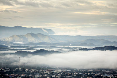 Aerial view of townscape and mountains against sky