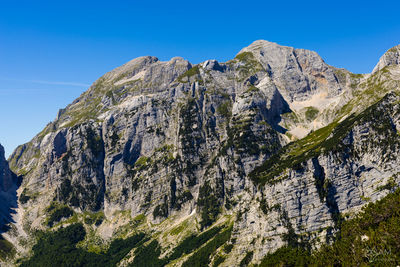 Low angle view of rock formation against clear blue sky