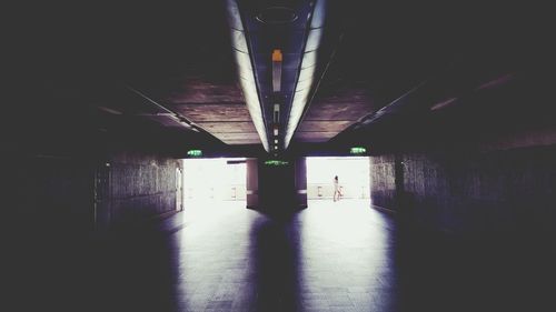 Surface level of silhouette people walking under bridge