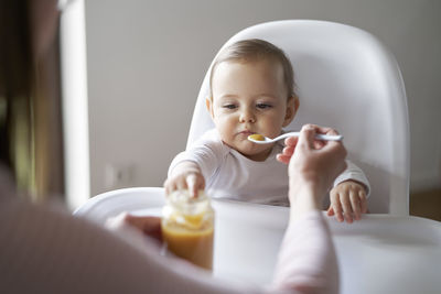 Portrait of smiling young woman having food at home