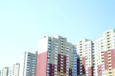 Low angle view of buildings against clear blue sky