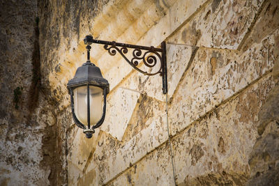 Low angle view of illuminated street light against building