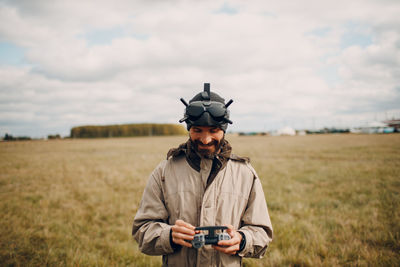 Portrait of man standing on field against sky