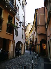 People walking on street amidst buildings in city