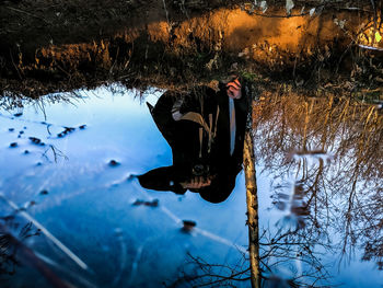 Reflection of man in puddle during winter