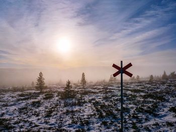 Scenic view of snow covered field against sky during sunset