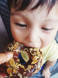 Cute boy eating donut at home