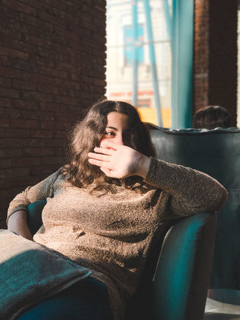 Young woman sitting on sofa at home