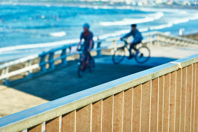 People riding bicycle on railing