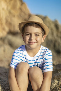 Portrait of smiling boy sitting on land
