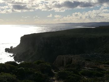 Scenic view of cliff by sea against sky