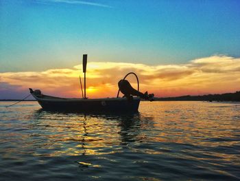 Silhouette boat in sea against sky during sunset