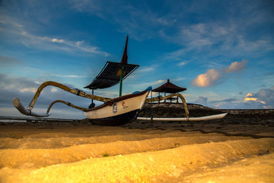 Ship moored on beach against sky