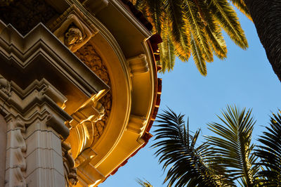 Low angle view of palm trees and building against sky