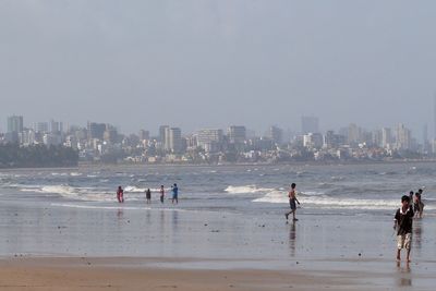 People on beach against clear sky