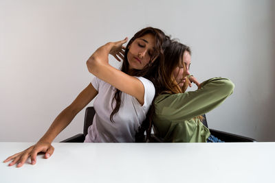 Beautiful young friends posing while sitting on table